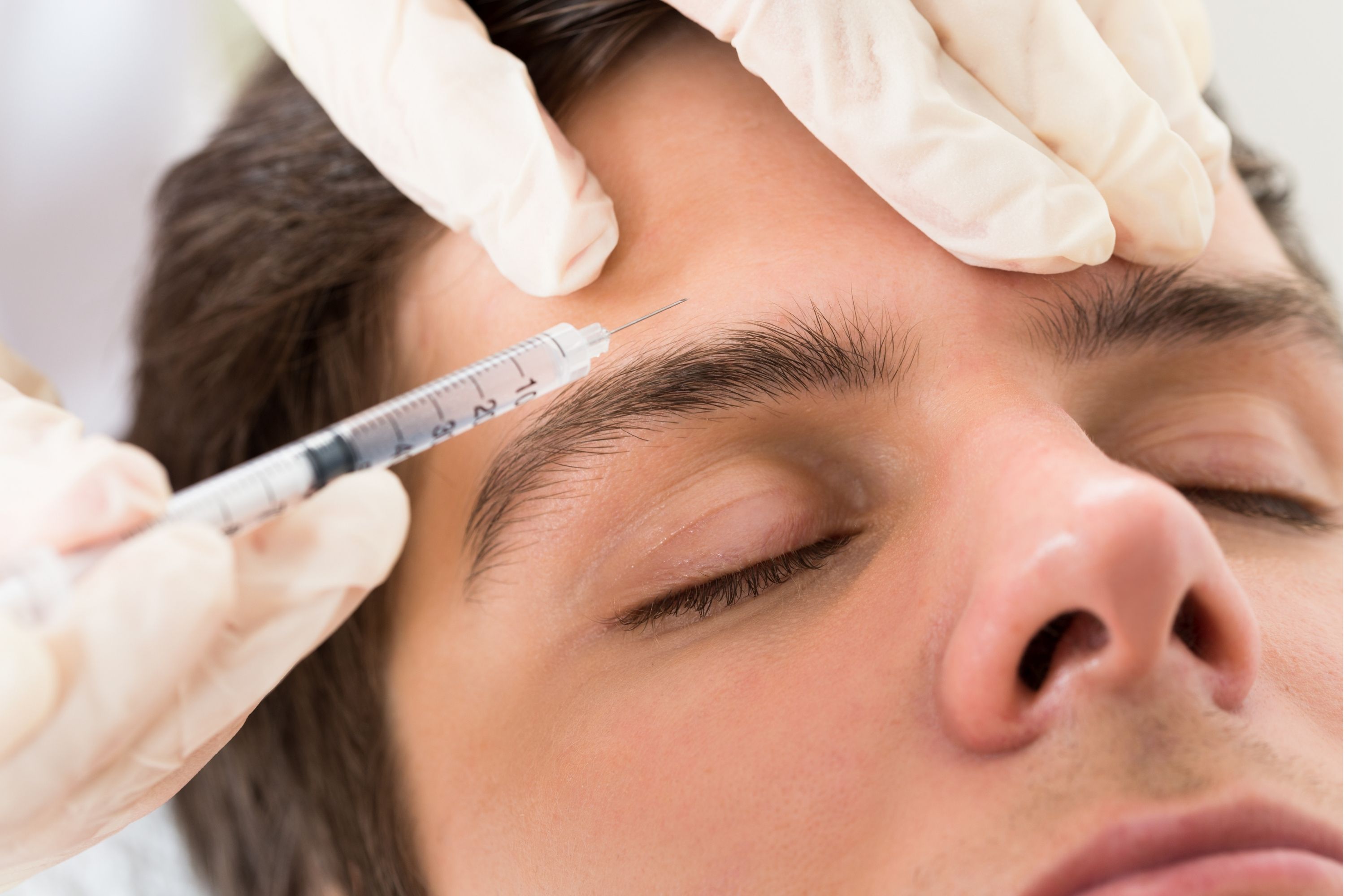 A man receiving Botox injections on the forehead