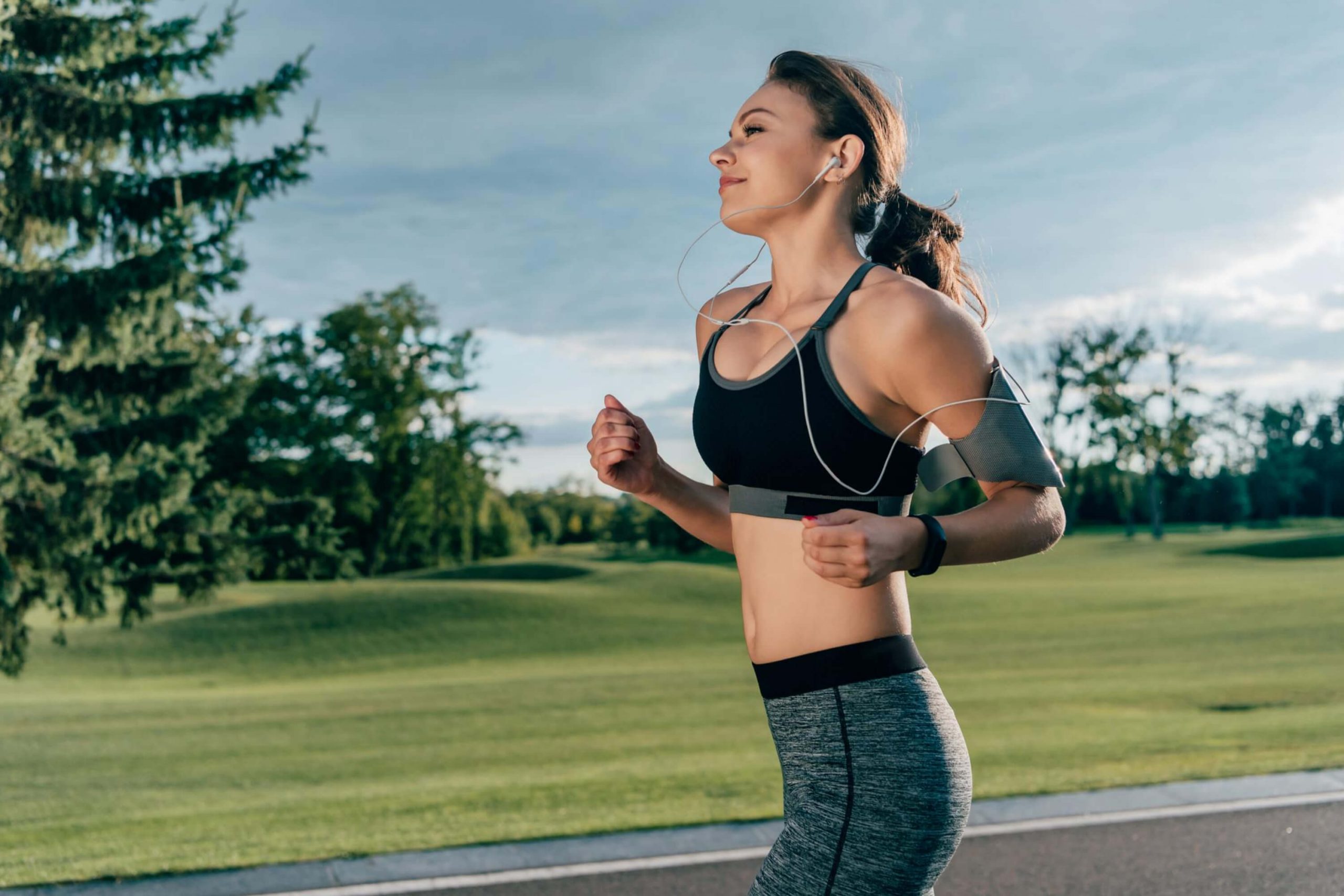 While running. Девушка на пробежке в наушниках. Девушка бежит в наушниках. Бег в наушниках. Человек на пробежке в наушниках.