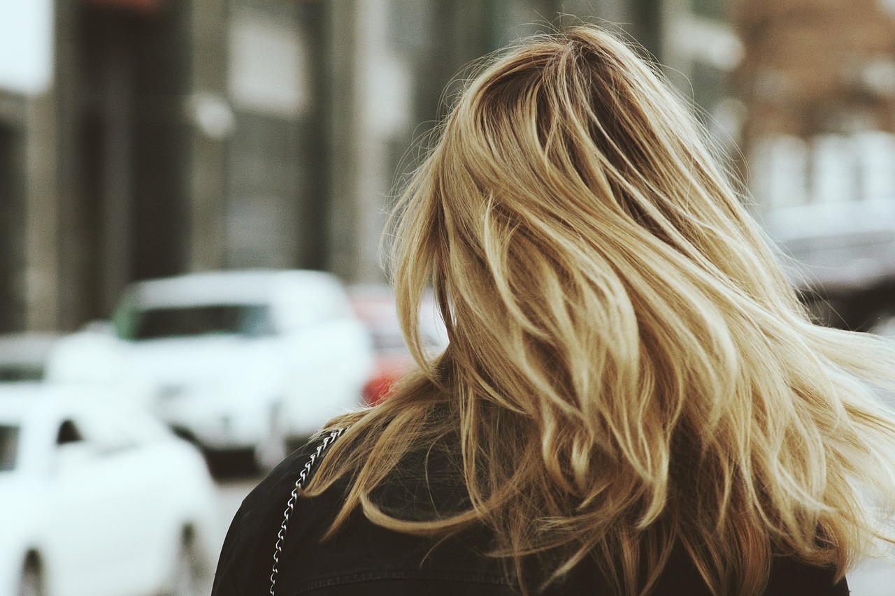 Woman with long, honey blonde hair looking over her shoulder