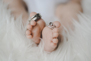 Newborn wearing delicate toe rings